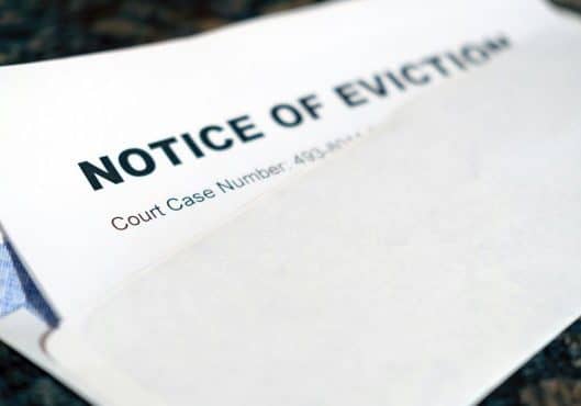 Photo by Allan Vega on Unsplash of a notice of eviction coming out of an envelope